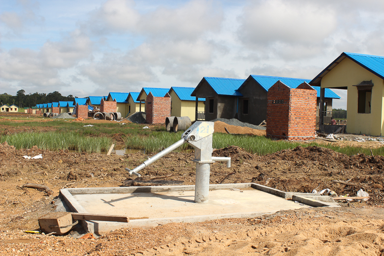 Houses under construction at the resettlement site for the Kbal Romeas commune, including a new hand water pump. The Cambodian government is relocating some 850 families from six villages that will be flooded by the Lower Sesan 2 dam. Photo credit: Anonymous. 