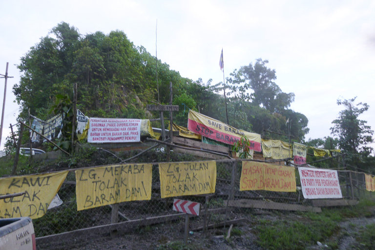 Banners outside the blockade camp at kilometer 15 of the Baram Dam access road. As part of a meeting of anti-dam activists this week, indigenous people from around the globe will join protesters at the camp. Photo courtesy of Bruno Manser Fonds.