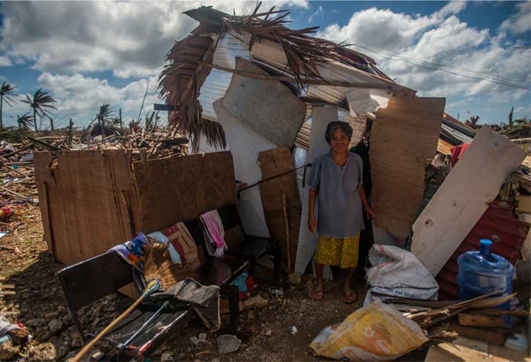 Super Typhoon Haiyan, November 15, 2013, the Philippines. A woman stands outside her makeshift shack in the storm’s aftermath. The world’s poor are the hardest hit by climate change. Photo by Mass Communication Specialist Seaman Liam Kennedy courtesy of the U.S. Navy. 