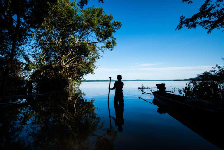 A member of the Munduruku indigenous group stands beside the Tapajós River, Pará state, Brazil. The Munduruku’s Sawré Muybu territory on the Tapajós is threatened by a proposed dam complex including the São Luiz do Tapajós dam. Those territorial claims were recently recognised by the Brazilian government, putting the licensing of the dam in doubt. Photo © Valdemir Cunha / Greenpeace