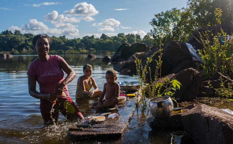 Dona Zefa preparing fish for dinner. Life along the Iriri River has its challenges, but also its rewards — the families living there want to stay in their homes. Photo by Mauricio Torres