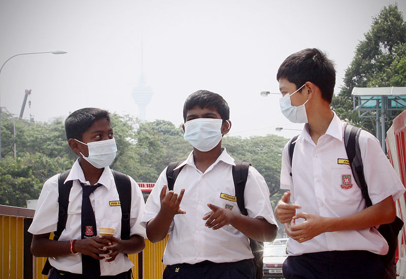 Malaysian schoolboys wear facemasks with Kuala Lumpur affected by haze pollution in 2012. Photo by Firdaus Latif/Wikimedia Commons