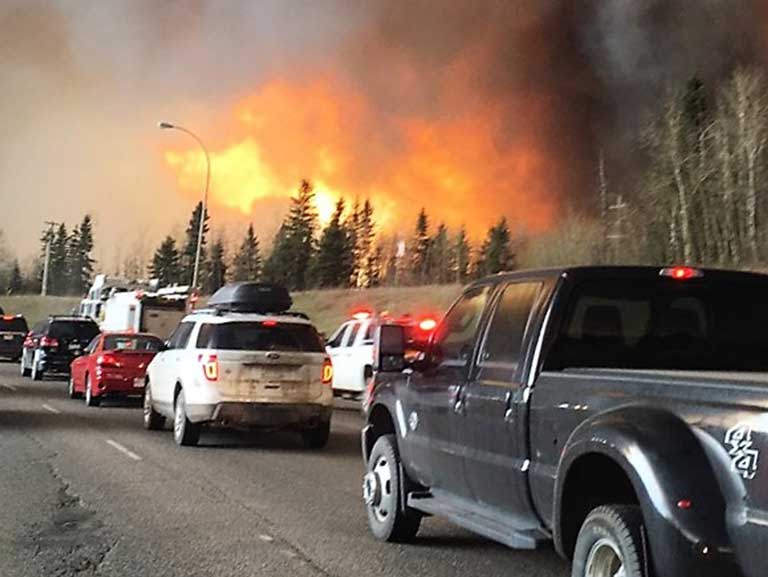 Industrialized world climate refugees: Fort Mcmurray residents flee the wildfires that have burned more than 20 percent of this Canadian community. Photo by DarrenRD licensed under the Creative-Commons Attribution Share-Alike 4.0 International license