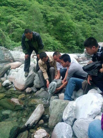 Guanba villagers release fish fry into the Guanba River in summer 2013. The village is working to restore a local catfish whose numbers had been reduced by overfishing. Photo Courtesy of Guanba village.