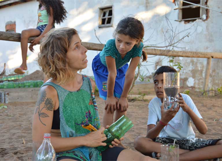 Marina Capriotti Donnini helps children create a seed sprouting system using a plastic bottle and a moist cloth. Photo by Zoe Sullivan