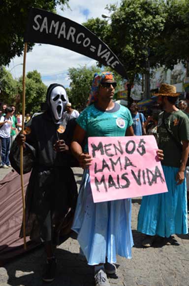 Marchers protest against Samarco, Vale and BHP Billiton after the Doce River Disaster. The sign reads: "Less mud, more life." Photo by Zoe Sullivan