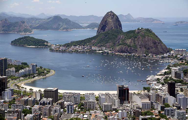 Though beautiful from above, Guanabara Bay is a dumping ground for raw sewage, hospital waste, trash, and a breeding ground of viruses, bacteria and fecal coliforms. Photo by Halley Pacheco de Oliveira licensed under the Creative Commons Attribution-Share Alike 3.0 Unported license 
