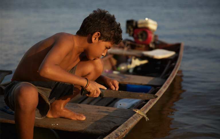 An indigenous boy fishing. The Munduruku report that the construction of the Teles Pires dam has damaged their fishery. Photo by Thais Borges