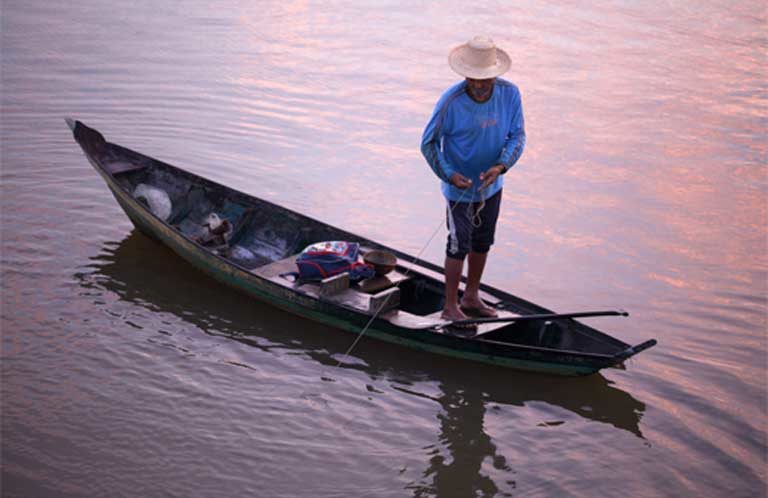 Early morning fishing on the Teles Pires River. River communities depend on fish for their diet and income. The Teles Pires dam is altering river temperatures and flow, concentrating agricultural pollutants, and has closed off migratory fish routes — all of which is harming the fishery. Despite that, the company that built the dam has won several sustainability awards. Photo by Thais Borges